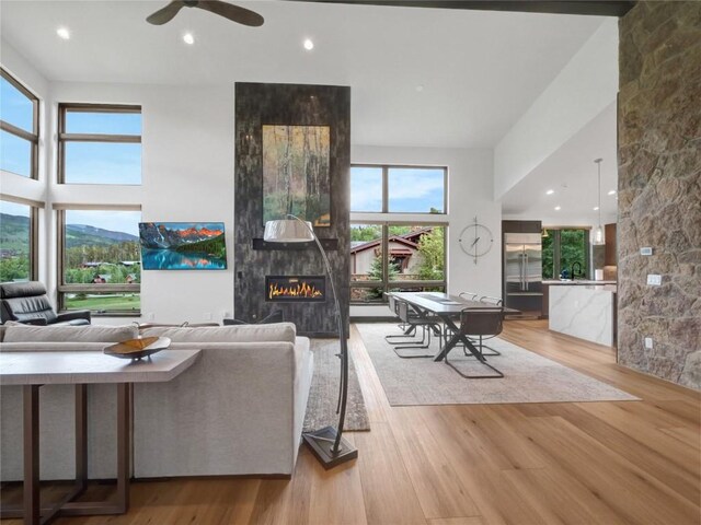 304 Raven Golf Ln, Silverthorne, CO 80498 - living room with a large fireplace, plenty of natural light, light wood-style flooring, a ceiling fan, and recessed lighting