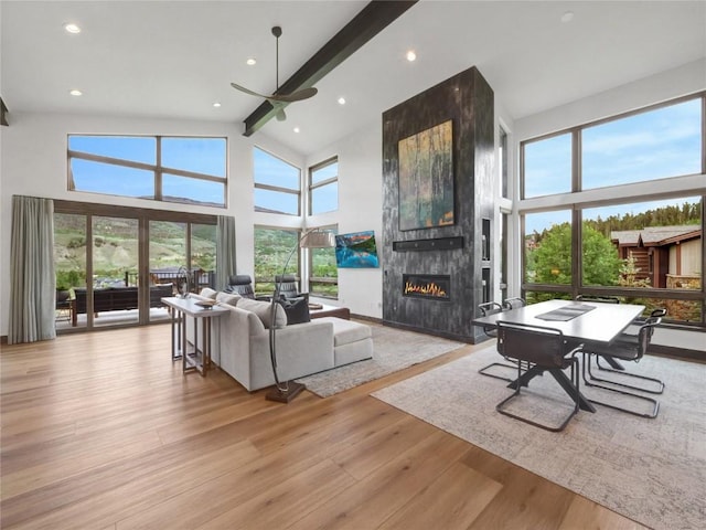 304 Raven Golf Ln, Silverthorne, CO 80498 - living room with a tiled fireplace, a ceiling fan, high vaulted ceiling, beamed ceiling, and wood finished floors