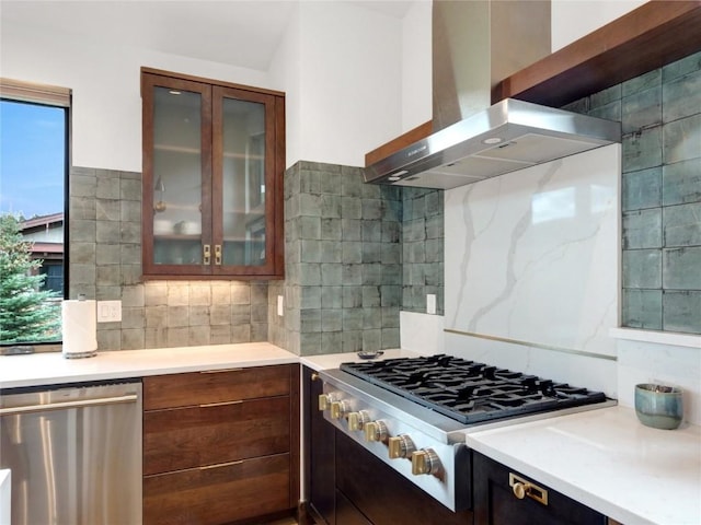 304 Raven Golf Ln, Silverthorne, CO 80498 - kitchen featuring wall chimney range hood, appliances with stainless steel finishes, backsplash, light countertops, and glass insert cabinets
