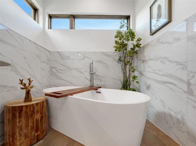 304 Raven Golf Ln, Silverthorne, CO 80498 - bathroom featuring tile walls, healthy amount of natural light, and a soaking tub