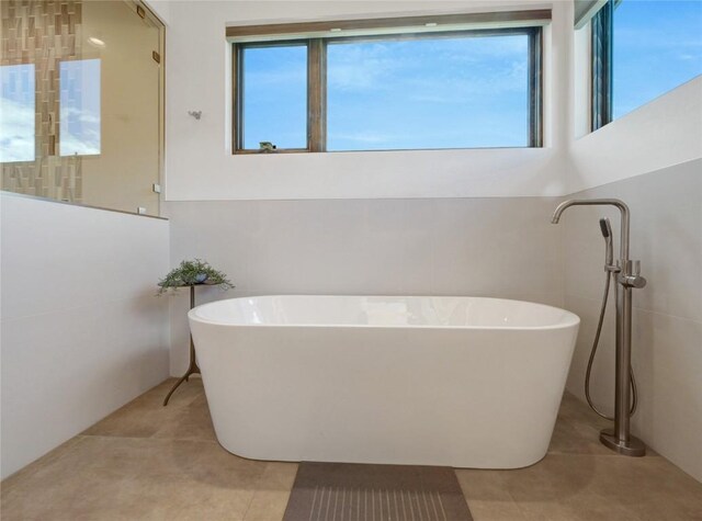 304 Raven Golf Ln, Silverthorne, CO 80498 - full bath with healthy amount of natural light, a soaking tub, and tile patterned flooring