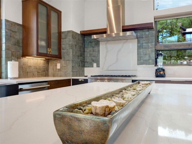 304 Raven Golf Ln, Silverthorne, CO 80498 - kitchen featuring island range hood, backsplash, and glass insert cabinets