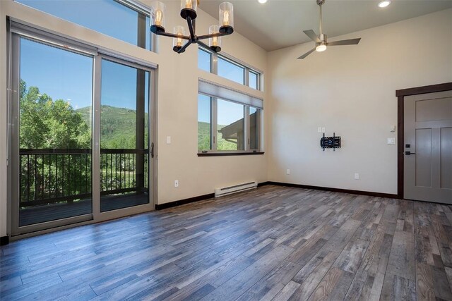 320 Fox Springs Cir Unit 302, Steamboat Springs, CO 80487 - spare room with a baseboard radiator, wood finished floors, a chandelier, a ceiling fan, and baseboards
