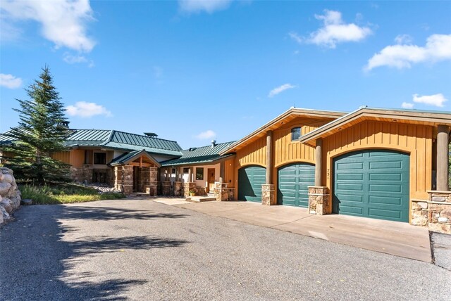 731 Lakeview Cir, Silverthorne, CO 80498 - view of front facade with a garage, stone siding, concrete driveway, metal roof, and a standing seam roof