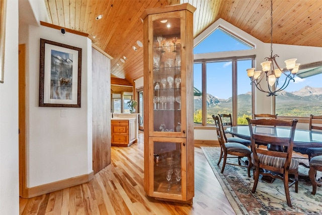 731 Lakeview Cir, Silverthorne, CO 80498 - dining room with lofted ceiling, baseboards, wood ceiling, a chandelier, and a mountain view