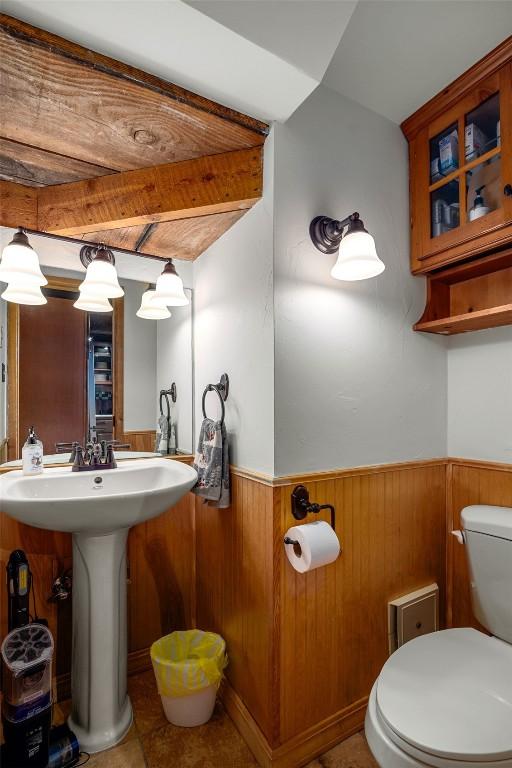 31500 Runaway Pl Unit 405, Steamboat Springs, CO 80487 - half bathroom with toilet, a wainscoted wall, wood walls, and a sink