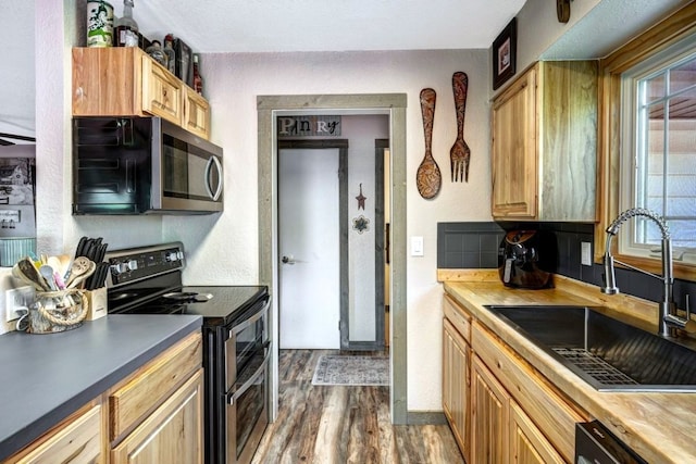 420 County Rd 130, Kremmling, CO 80459 - kitchen with appliances with stainless steel finishes, a sink, dark wood-style floors, and light brown cabinetry