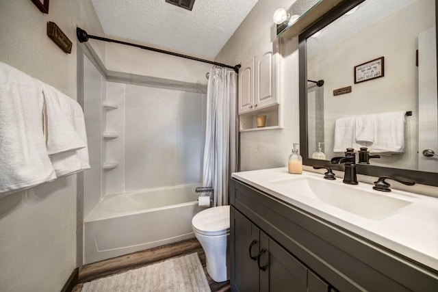 420 County Rd 130, Kremmling, CO 80459 - full bath featuring wood finished floors, shower / bath combo, vanity, toilet, and a textured ceiling