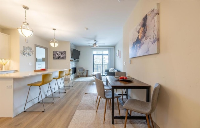 75 W 4th St Unit 206, Silverthorne, CO 80497 - dining room with light wood-type flooring, ceiling fan, and a stone fireplace