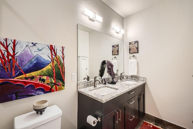 bathroom featuring double vanity, tile patterned floors, toilet, and a sink