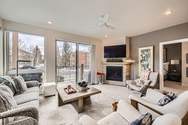 living room featuring a ceiling fan, a fireplace, and recessed lighting