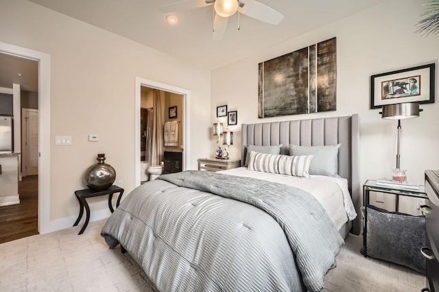 bedroom with a ceiling fan, light wood-style floors, stainless steel fridge, ensuite bath, and baseboards
