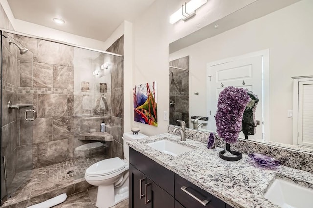 bathroom featuring vanity, toilet, and a stall shower