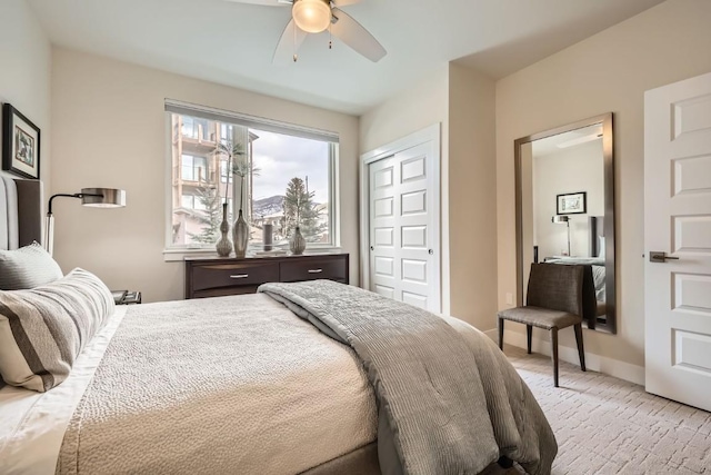 bedroom with a ceiling fan, baseboards, a closet, and light colored carpet