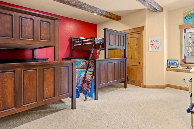bedroom with baseboards, beamed ceiling, and carpet flooring