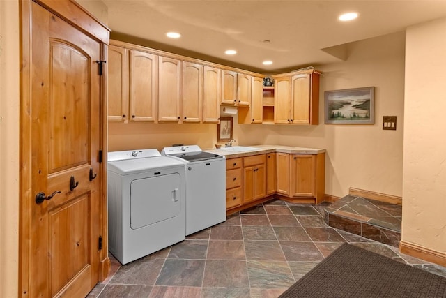 clothes washing area featuring recessed lighting, washer and clothes dryer, cabinet space, and stone finish floor