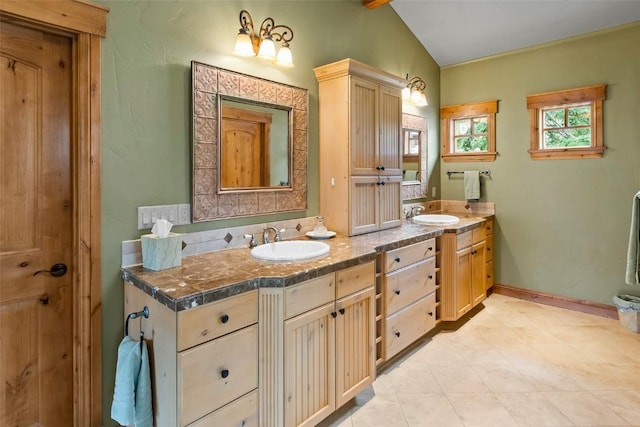 full bathroom featuring double vanity, vaulted ceiling with beams, tile patterned floors, and a sink
