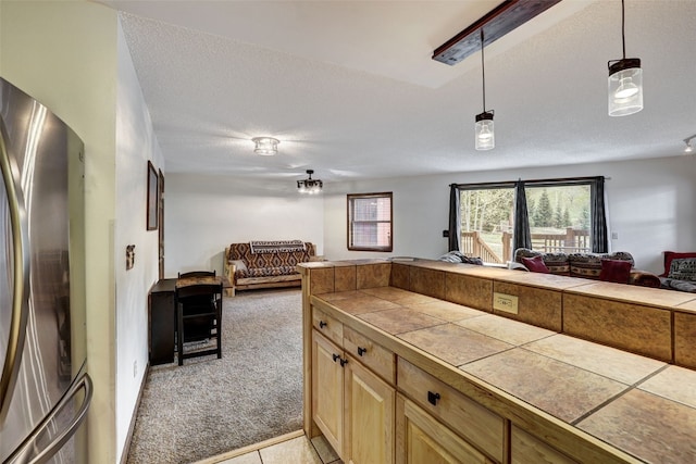 840 Four Oclock Rd Unit A1D, Breckenridge, CO 80424 - kitchen featuring open floor plan, freestanding refrigerator, tile counters, light carpet, and light brown cabinets