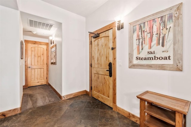 interior space with visible vents, baseboards, and stone finish floor