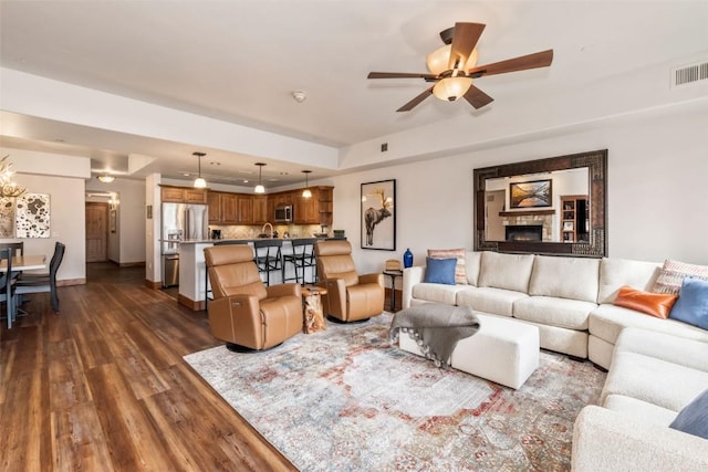 living room with a ceiling fan, baseboards, recessed lighting, visible vents, and dark wood-style floors