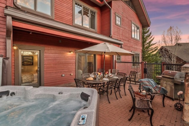 view of patio featuring a hot tub, outdoor dining space, and grilling area