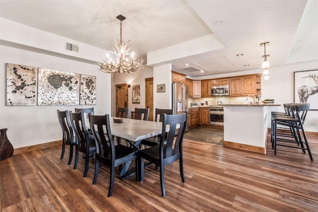 dining space with baseboards, a notable chandelier, dark wood-style flooring, and visible vents
