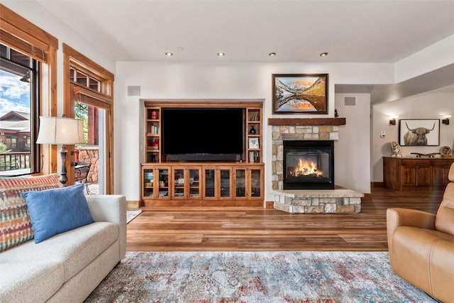 living room featuring a fireplace, recessed lighting, wood finished floors, and visible vents