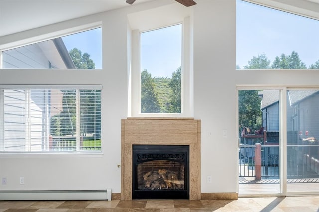 1921 Walton Creek Rd Unit 4, Steamboat Springs, CO 80487 - living room with a baseboard heating unit, a fireplace, ceiling fan, healthy amount of natural light, and a high ceiling