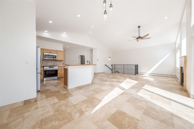 1921 Walton Creek Rd Unit 4, Steamboat Springs, CO 80487 - kitchen featuring appliances with stainless steel finishes, lofted ceiling, decorative backsplash, open floor plan, and ceiling fan