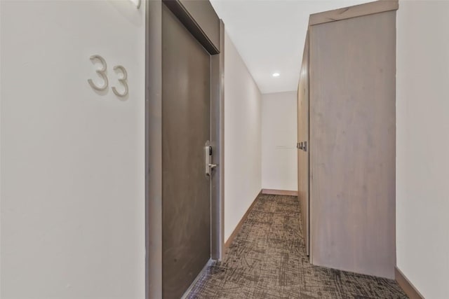 corridor with baseboards, dark carpet, and recessed lighting