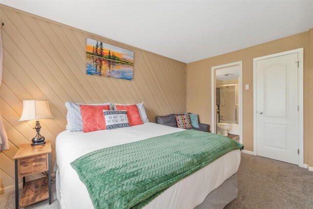 carpeted bedroom featuring baseboards and ensuite bathroom