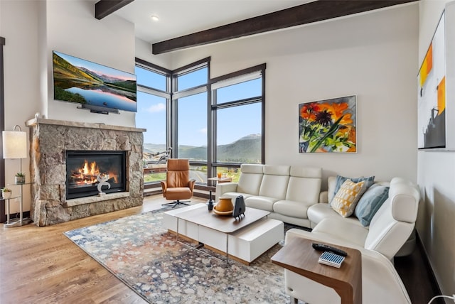 14 E Baron Way, Silverthorne, CO 80498 - living room with beamed ceiling, wood finished floors, plenty of natural light, and a stone fireplace