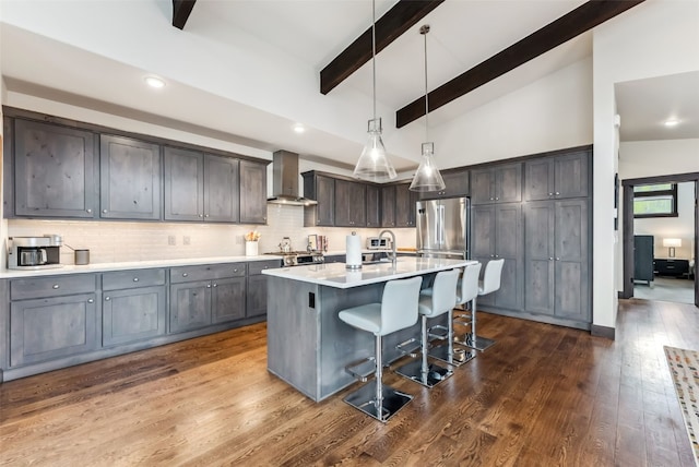 14 E Baron Way, Silverthorne, CO 80498 - kitchen featuring wall chimney range hood, freestanding refrigerator, a breakfast bar area, decorative backsplash, and recessed lighting