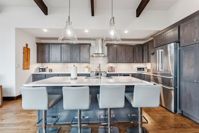 14 E Baron Way, Silverthorne, CO 80498 - kitchen featuring high end fridge, wall chimney range hood, beam ceiling, light countertops, and dark brown cabinetry