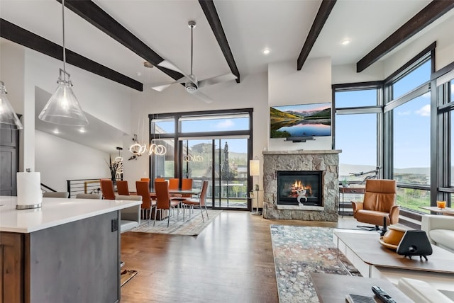 14 E Baron Way, Silverthorne, CO 80498 - living area featuring wood finished floors, healthy amount of natural light, beam ceiling, and a stone fireplace