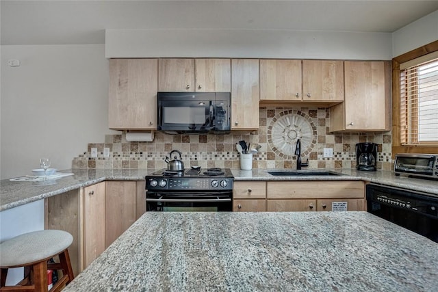kitchen with light stone counters, light brown cabinets, a sink, and black appliances