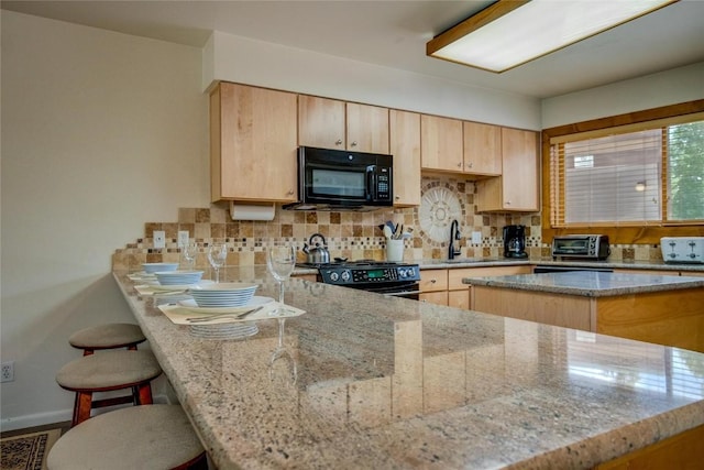 kitchen featuring light stone countertops, light brown cabinetry, a sink, and black appliances