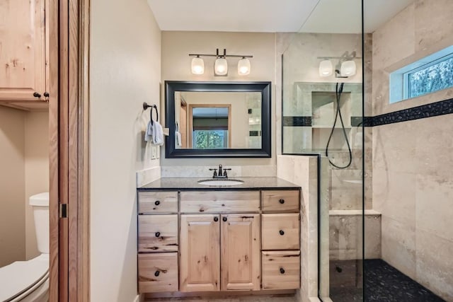 full bath with vanity, toilet, and a tile shower