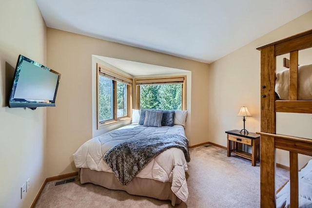 carpeted bedroom featuring visible vents and baseboards