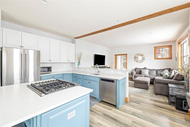 186 Rachel Ln, Breckenridge, CO 80424 - kitchen featuring blue cabinets, stainless steel appliances, a peninsula, and open floor plan