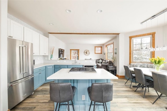 186 Rachel Ln, Breckenridge, CO 80424 - kitchen featuring blue cabinetry, a peninsula, appliances with stainless steel finishes, and light countertops
