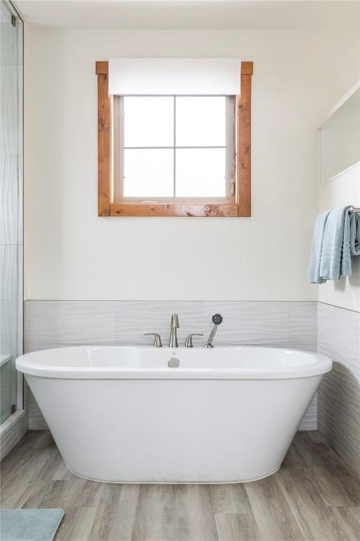 186 Rachel Ln, Breckenridge, CO 80424 - full bathroom featuring tile walls, wainscoting, wood finished floors, and a soaking tub
