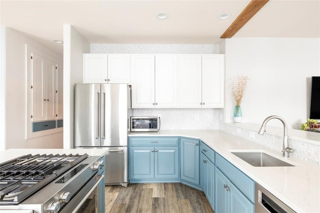 186 Rachel Ln, Breckenridge, CO 80424 - kitchen featuring blue cabinets, stainless steel appliances, a sink, light wood-style floors, and light countertops