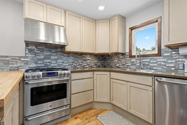 329 N Chipmunk Cir, Silverthorne, CO 80498 - kitchen with appliances with stainless steel finishes, exhaust hood, wood counters, light wood-style flooring, and cream cabinetry