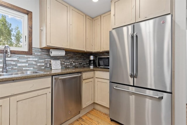 329 N Chipmunk Cir, Silverthorne, CO 80498 - kitchen with stainless steel appliances, cream cabinets, decorative backsplash, and dark countertops