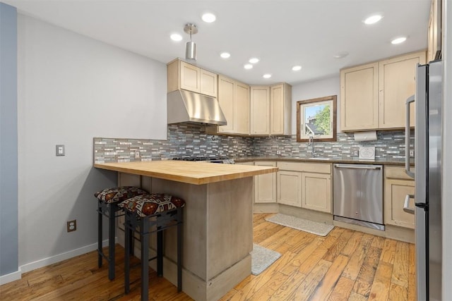 329 N Chipmunk Cir, Silverthorne, CO 80498 - kitchen with stainless steel appliances, under cabinet range hood, cream cabinetry, butcher block countertops, and recessed lighting