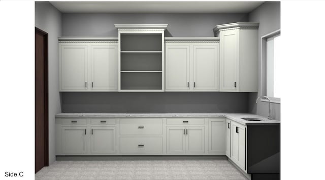 kitchen featuring white cabinetry and sink