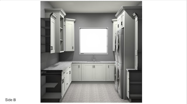 kitchen with white cabinetry, sink, and stacked washer and clothes dryer