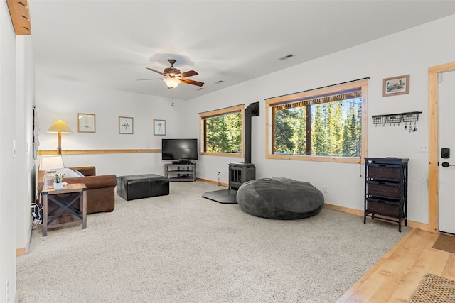 1205 Mountain View Dr, Fairplay, CO 80440 - carpeted living area with a wood stove, ceiling fan, and baseboards
