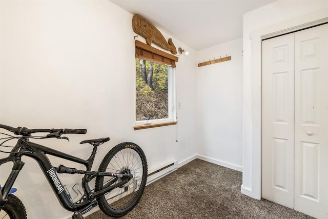 misc room featuring dark carpet, baseboards, and a baseboard heating unit